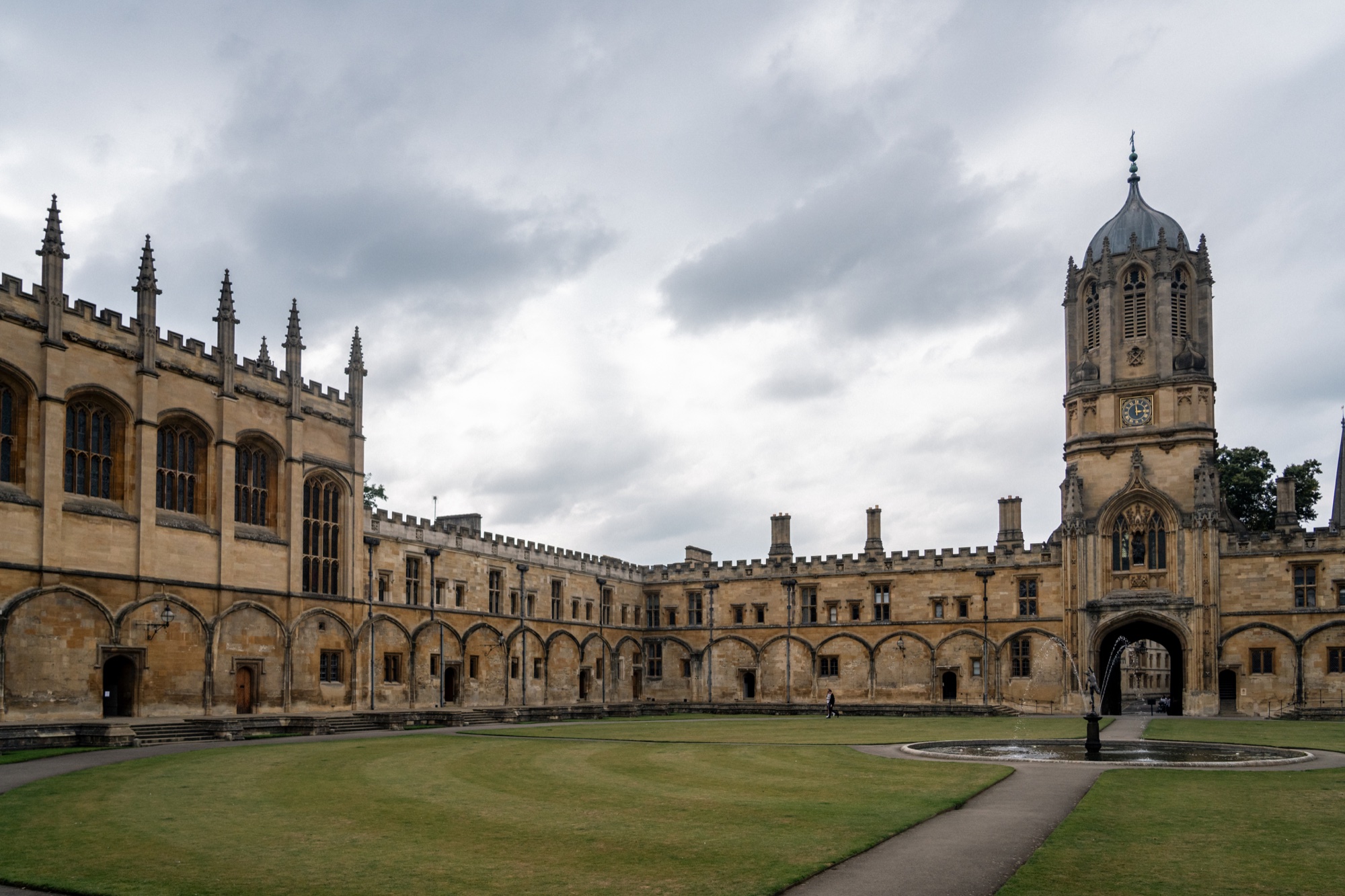 Historic Oxford quadrangle with a broad lawn, arched stone buildings, and a central tower