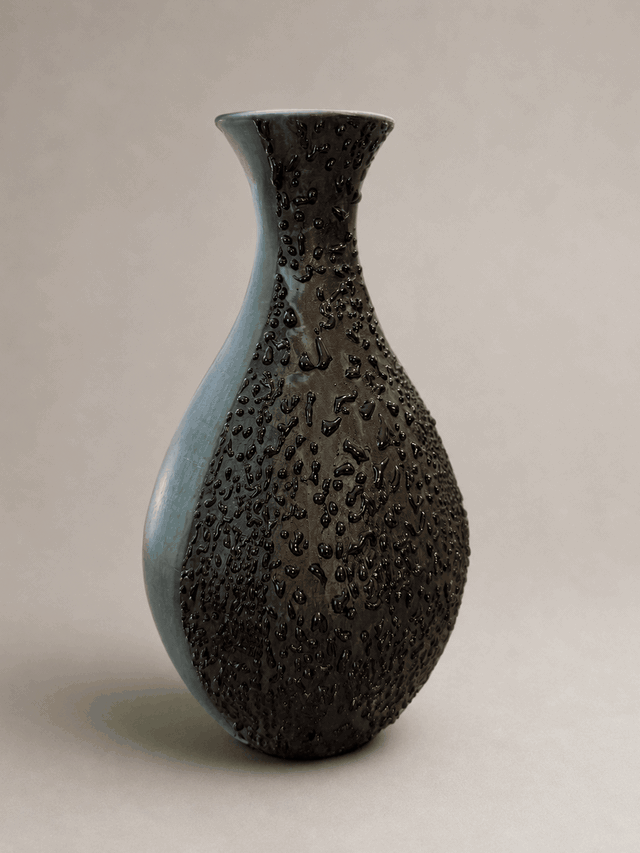 Rotating view of a blue-green terra sigillata vase revealing its glossy black textured passage